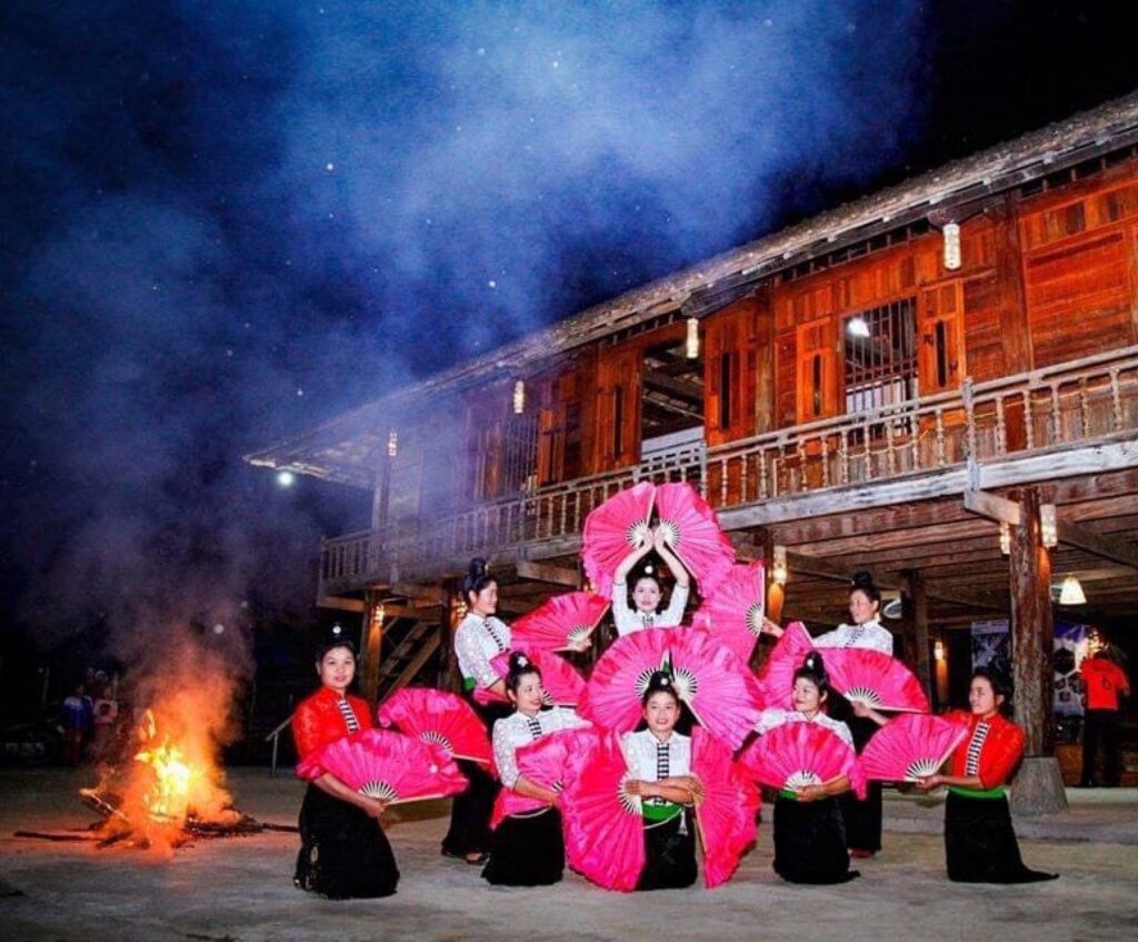 Danse aux éventails près du feu, sous une maison sur pilotis